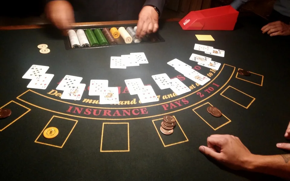 A dealer's hands laying out cards on a blackjack table