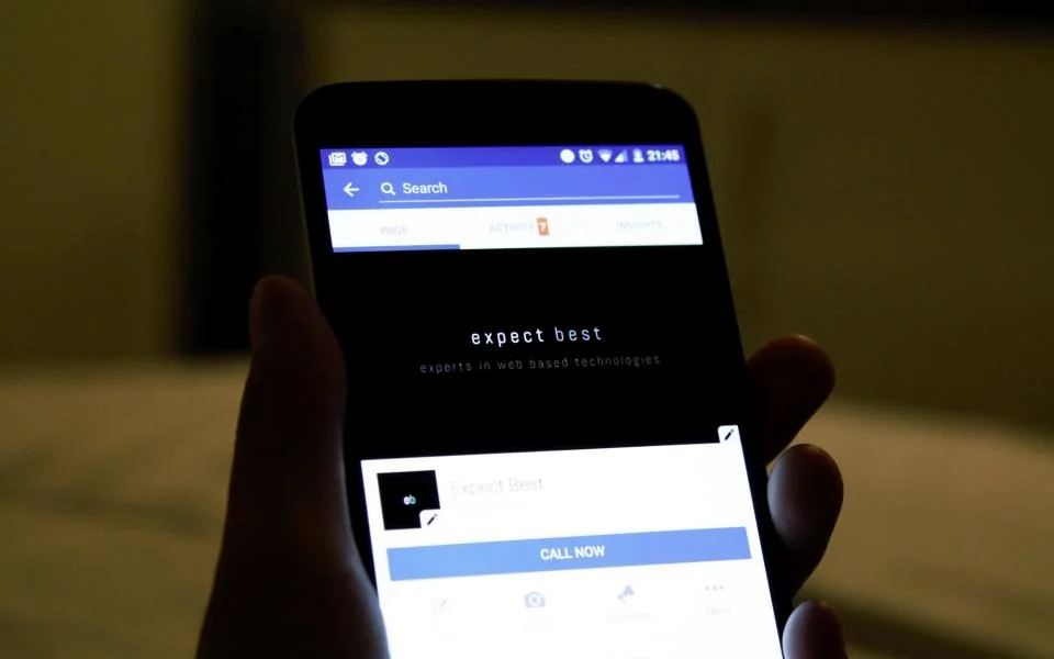 A hand holding a phone with a call screen open