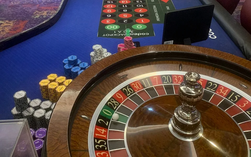A roulette wheel and chips on the layout of a casino table