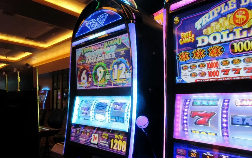 A row of lit slot machines in a casino hall
